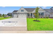Charming two-story home with a three-car garage, well-manicured lawn, and traditional architectural design at 7076 Denim Loop, Myrtle Beach, SC 29579