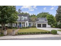 Charming two-story home featuring a well-manicured front lawn, inviting porch, and attached two-car garage at 9340 Lake Dr., Myrtle Beach, SC 29572
