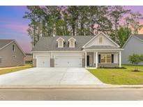 Two-story house with gray siding, three-car garage, and a landscaped lawn at 3344 Little Bay Dr., Conway, SC 29526