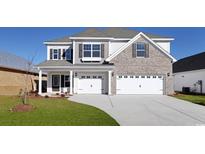 Charming two-story home featuring a two-car garage, manicured lawn, and a mix of brick and siding at 332 Happy Valley Dr., Myrtle Beach, SC 29588