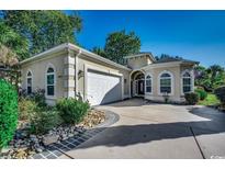 Charming home featuring lush landscaping, a two-car garage, and an inviting front entrance at 8556 Juxa Dr., Myrtle Beach, SC 29579