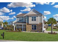Two story home with stone and siding accents, welcoming front porch and landscaped yard at 935 Desert Wheatgrass Dr., Myrtle Beach, SC 29579