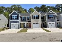 New townhomes boast attached garages, colorful doors, and modern exterior finishes at 259 Christiana Ln. # E, Myrtle Beach, SC 29579