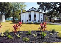 Charming home with a white exterior, black trim, well-maintained lawn, and lovely landscaping at 37 Geney Ln., Pawleys Island, SC 29585