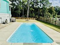 Backyard features a refreshing in-ground pool, perfect for hot summer days and outdoor entertainment at 3936 Murrells Inlet Rd., Murrells Inlet, SC 29576