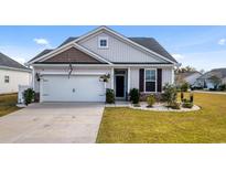 Charming single-story home featuring a two-car garage, stone accents, and manicured lawn at 263 Red Maple Loop, Longs, SC 29568