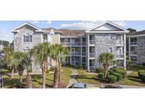 Attractive multi-story condominium building with tropical landscaping and well-maintained common areas at 4749 Wild Iris Dr. # 304, Myrtle Beach, SC 29577