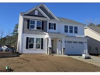 Two-story home with white siding, gray accents, a covered porch, and an attached two-car garage at 5024 Cambria Ct., Little River, SC 29566