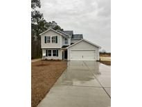 Two-story house with gray siding, a white garage door, and a neatly landscaped yard at 761 Busy Corner Rd., Conway, SC 29527