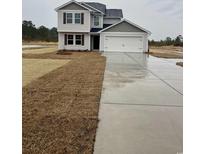 Two-story house with gray siding, a two-car garage, and a large yard at 769 Busy Corner Rd., Conway, SC 29527