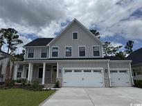 Charming two-story home featuring a two-car garage, landscaped yard, and inviting front porch with columns at 2249 Vera Way, Longs, SC 29568