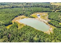 A lovely aerial view of a property with a pond surrounded by lush green trees at 7299 Cartrette Rd., Aynor, SC 29511