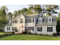 Beautiful two-story home with white siding, black shutters, manicured lawn and an American flag at 121 Grand Palm Ct., Myrtle Beach, SC 29579