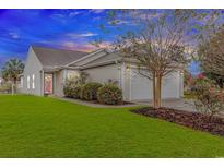 Charming single-story home featuring a two-car garage, well-manicured lawn, and beautiful landscaping at 133 Junco Circle, Longs, SC 29568