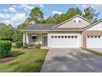 Charming home featuring a two-car garage, manicured lawn and welcoming entryway with light-blue accents at 101 Fulbourn Pl., Myrtle Beach, SC 29579
