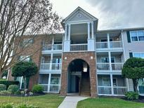 Exterior of a multi-story condo building with brick accents, balconies, and well-maintained landscaping at 3735 Block House Way # 113, Myrtle Beach, SC 29577