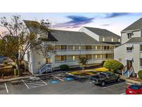 Attractive condo building with designated parking spots and well-maintained landscaping at 1100 Possum Trot Rd. # B202, North Myrtle Beach, SC 29582