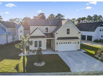 Charming two-story home featuring a spacious driveway, manicured lawn, and tasteful landscaping at 1256 Fiddlehead Way, Myrtle Beach, SC 29579