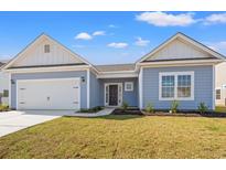 Charming one-story home with light blue siding, a two-car garage, and a well-manicured lawn at 387 Lifestyle Court, Surfside Beach, SC 29575