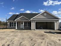 Newly constructed home with gray siding, a two-car garage, and a front porch at 479 Highway 348, Loris, SC 29569