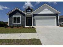 Charming home featuring navy blue siding, white trim, and a spacious two-car garage at 8640 Farrier Dr., Myrtle Beach, SC 29588