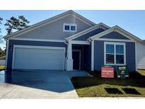 Charming single-story home with blue siding, white trim, and an attached two-car garage at 8663 Farrier Dr., Myrtle Beach, SC 29588