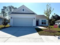 New construction home boasts white siding, two-car garage, and a well-manicured front yard at 8667 Farrier Dr., Myrtle Beach, SC 29588