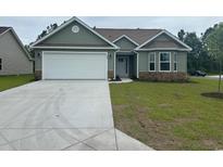 Charming single-story home with green siding, stone accents, a white garage door, and a well-maintained front lawn at 910 Padgett Lane, Conway, SC 29526