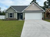 Newly constructed home featuring a two-car garage and a neatly landscaped lawn at 910 Padgett Lane, Conway, SC 29526