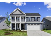 Charming two-story home with a spacious front yard, two car garage, and inviting covered porch at 5015 Cambria Ct., Little River, SC 29566