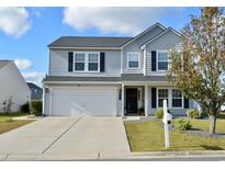 Charming two-story home with a gray exterior, well-manicured lawn, and a two-car garage at 276 Palmetto Glen Dr., Myrtle Beach, SC 29588