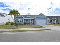Charming blue home with palm tree, two-car garage, and well-manicured lawn at 405 Grain Field Dr., Georgetown, SC 29440