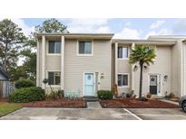 Charming townhouse featuring neutral siding, a light blue door, and a small patio area at 951 Plantation Dr. # F1, Little River, SC 29566