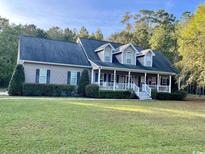 Charming home featuring a welcoming front porch, dormer windows, and a well-maintained lawn at 2347 Devine St., Georgetown, SC 29440