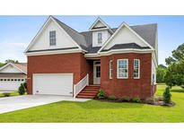 Charming brick home with a well-manicured lawn and attached two-car garage at 428 Meadow View Ct., Longs, SC 29568