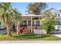 Charming single-story home featuring a large front porch, well-kept lawn, and a mature palm tree at 6001-S32 S Kings Hwy., Myrtle Beach, SC 29575