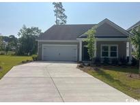 Charming single-story home featuring a wide driveway and attached two-car garage at 9742 Indigo Creek Blvd., Murrells Inlet, SC 29576