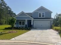 Charming single-Gathering home featuring a welcoming facade, manicured lawn, and a two-car garage at 9746 Indigo Creek Blvd., Murrells Inlet, SC 29576