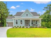 Charming single-Gathering home with blue siding, a welcoming front porch, and a well-manicured lawn at 852 Comanders Island Rd., Georgetown, SC 29440