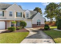 Well-maintained townhome with a one-car garage, manicured lawn, and mature landscaping at 130 Wimbledon Way # 130, Murrells Inlet, SC 29576