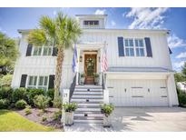 Beautiful white two-story home with black shutters, palm tree, American flag, and elegant front entrance at 14 Flaggpoint Ln., Murrells Inlet, SC 29576