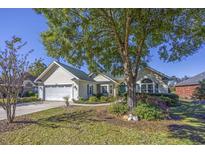 Charming single-story home featuring a well-manicured front yard and a two-car garage at 565 Bucks Trail, Longs, SC 29568