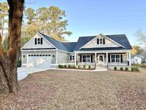Inviting home featuring a black roof, black trim, and a light-colored siding at 1006 Cuttino St., Georgetown, SC 29440