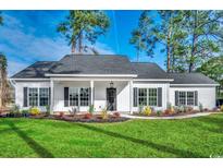 Charming single-story home featuring a landscaped front yard, black shutters, and a covered front porch at 157 Bay Circle Dr., Loris, SC 29569