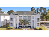 Three story condo with white balconies, green shutters, and palm trees in front at 556 White River Dr. # 44F, Myrtle Beach, SC 29579