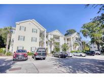 Low-angle shot of a condo building with multiple stories, balconies, and parking spaces for residents and visitors at 601 Hillside Dr. N # 4133, North Myrtle Beach, SC 29582