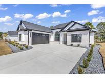 Beautiful, modern home with a black garage door and white brick exterior at 1054 Englemann Oak Dr., Myrtle Beach, SC 29579