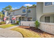 Inviting exterior of a light gray townhouse with American flags and well-manicured landscaping at 23 Shadow Moss Pl. # 23, North Myrtle Beach, SC 29582
