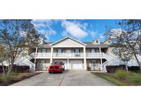 Inviting two-story condo with well-maintained landscaping, white railings, and attached garages on a sunny day at 822 Sail Ln. # 103, Murrells Inlet, SC 29576