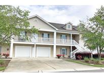 Inviting townhouse showcasing a double garage, white railing balcony, and well-maintained landscaping at 822 Sail Ln. # 103, Murrells Inlet, SC 29576